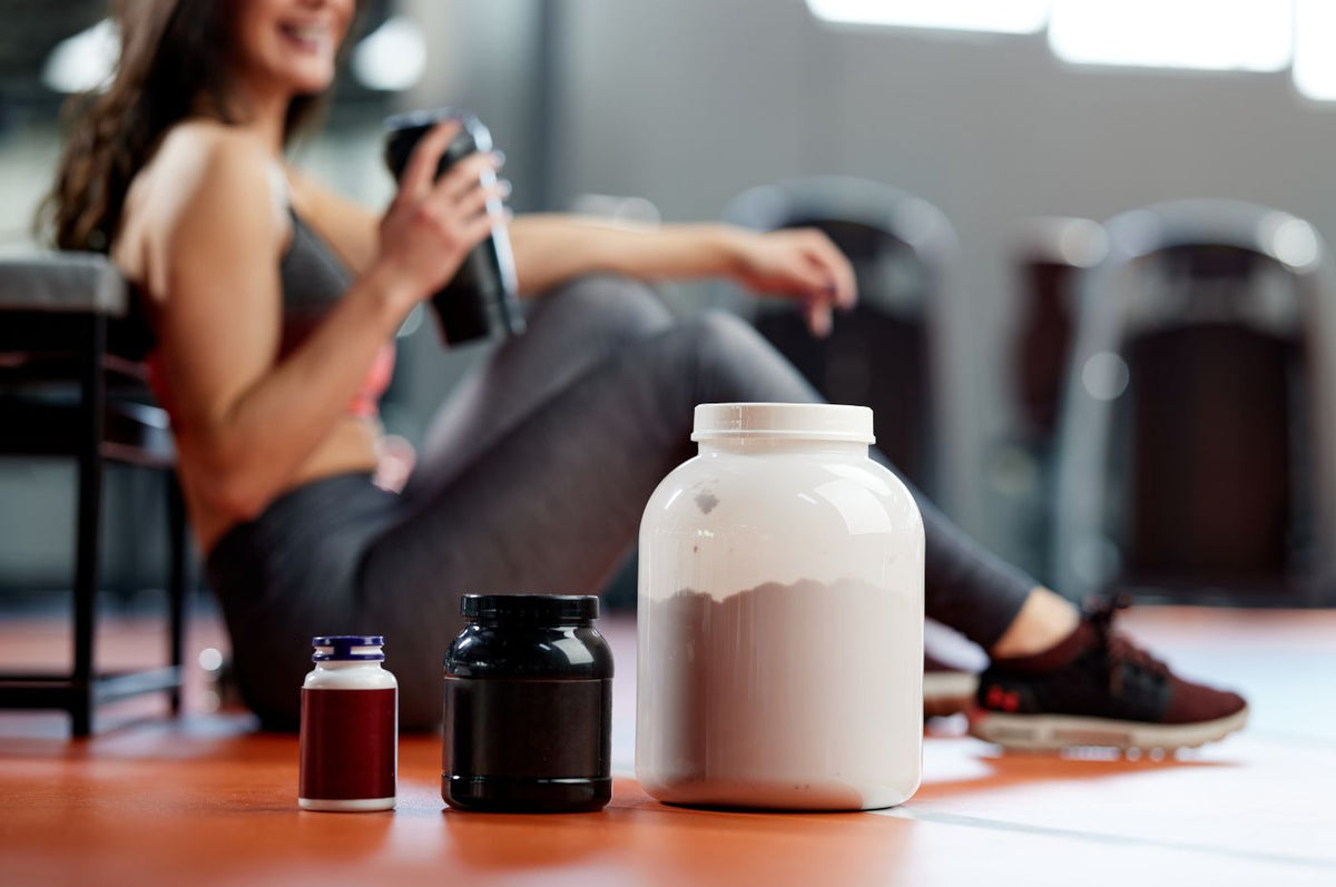 Kvinde med shaker og proteinpulver efter træning
